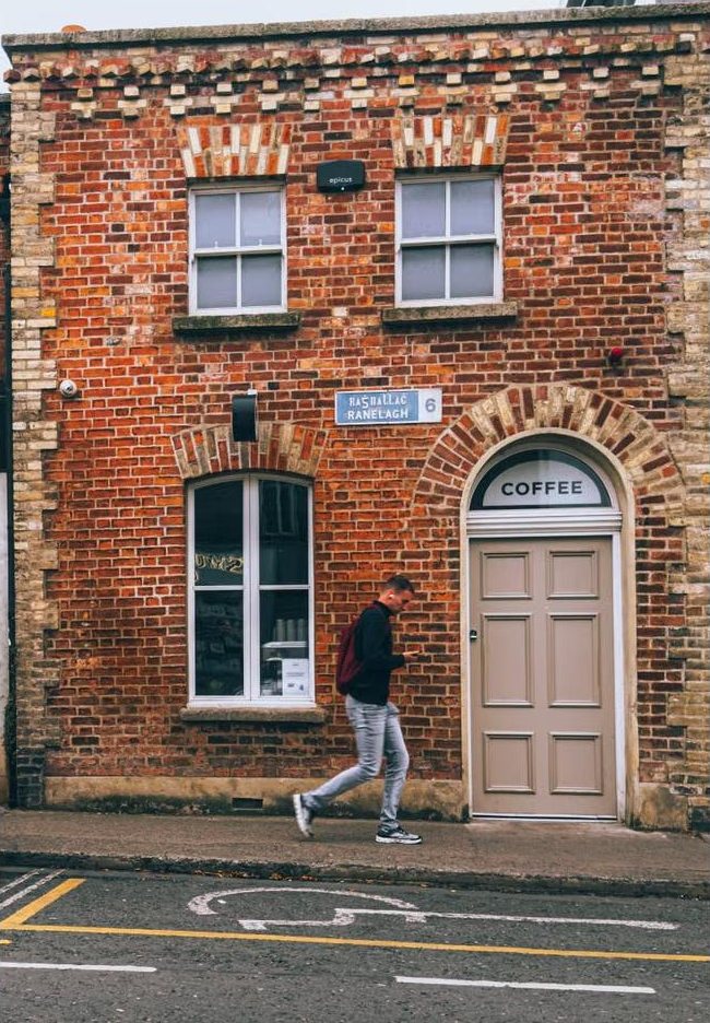Red-brick commercial building with an arched doorway on a city street